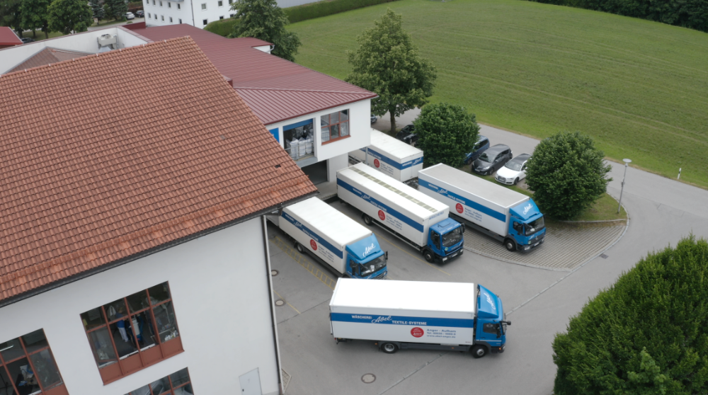 Luftaufnahme von der Schmutzwäsche Rampe an der drei LKWs stehen und einer gerade los fährt